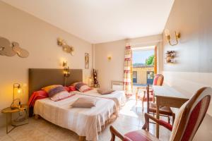 two beds in a room with a table and chairs at La Ferme des Grisettes in Montesquiou