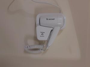 a phone with a cord plugged into a wall at Restel Guest House in Guwahati