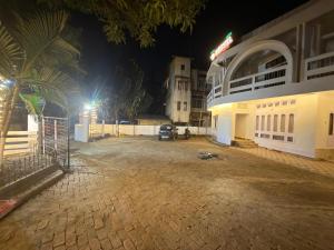 a parking lot in front of a building at night at Restel Guest House in Guwahati