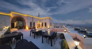 a patio with tables and chairs and a building at Vezir Konağı Hotel in Mardin