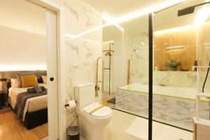 a bathroom with a toilet and a bed and a tub at Sweet Suites in Valencia +22 photos