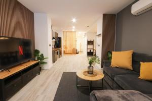 a living room with a couch and a tv at Sweet Suites in Valencia