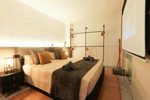 a bedroom with a large bed and a projection screen at Sweet Suites in Valencia