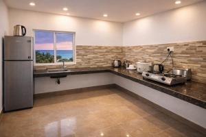 a kitchen with a counter with a sink and a refrigerator at Blue Diamond Resort in Trincomalee