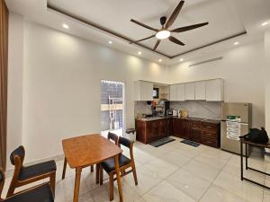 a kitchen with a table and a ceiling fan at Miha Villa 3 - House in Can Tho in Can Tho