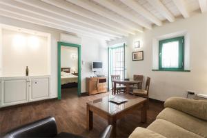 ein Wohnzimmer mit einem Sofa und einem Tisch in der Unterkunft Laurel Suites Apartments in Granada