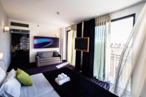 um quarto de hotel com uma cama e uma janela grande em Eyal Hotel by Smart Hotels em Jerusalém
