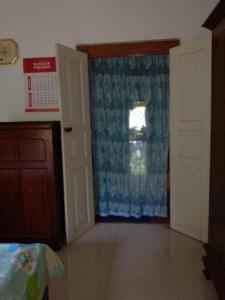 a room with a door with a curtain and a window at Uswatta in Matara