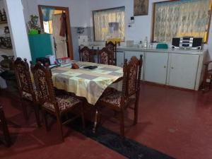 a dining room with a table and chairs and a kitchen at Uswatta in Matara