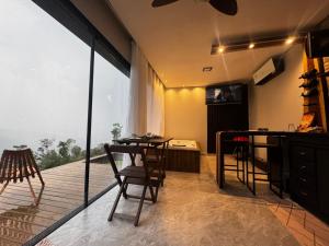 a room with a balcony with a table and chairs at Chalés Refúgio nas montanhas in Guaratuba