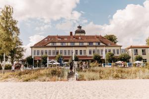 a building on the beach in front of a building at Zeitlos Hotel Garni in Scharbeutz