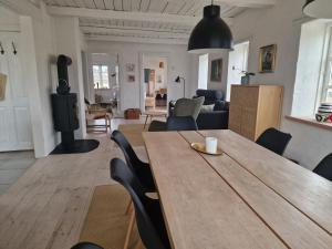 ein Esszimmer und ein Wohnzimmer mit einem Holztisch und Stühlen in der Unterkunft Strandhuset in Agger