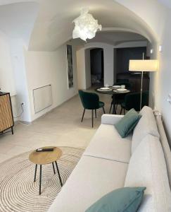 a living room with a white couch and a table at Art apartment Kranj in Kranj