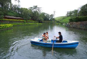 three people in a blue boat on a river at Saj Vagamon Hideout in Vagamon +67 photos