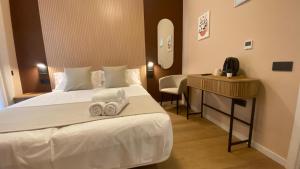 a hotel room with a bed with towels on it at Marina Boutique in Valencia