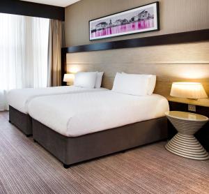 Un pat sau paturi într-o cameră la Leonardo Hotel Cardiff