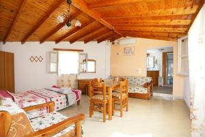 a living room with a table and chairs and a bedroom at Katina Balos Rooms-Studios in Koumeika