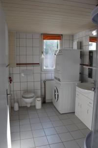 ein kleines weißes Bad mit einem WC und einem Waschbecken in der Unterkunft Maisonette im Hof Krupp in Bruchhausen