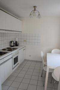 een keuken met witte apparatuur en een tafel en stoelen bij Maisonette im Hof Krupp in Bruchhausen