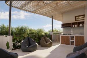 a patio with two bean chairs and a kitchen at Mecutan Guest House in Jimbaran