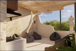 a patio with couches and chairs in a building at Mecutan Guest House in Jimbaran