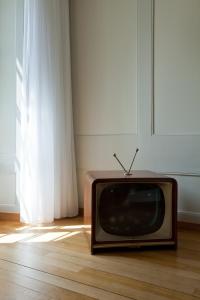 una vieja televisión sentada en el suelo en una habitación en Hotel Restaurant Schwert Thun, en Thun