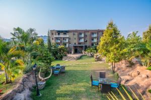 an apartment building with a yard with tables and chairs at Hotel La vena in Kampala