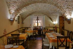 a restaurant with tables and chairs and a brick ceiling at Casa Rural La Chimenea in Navas del Madroño