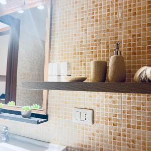 a bathroom with a sink and a mirror and a shelf at Elisabeth home in Modica