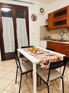 a kitchen with a white table with chairs and fruit on it at Elisabeth home in Modica +10 photos