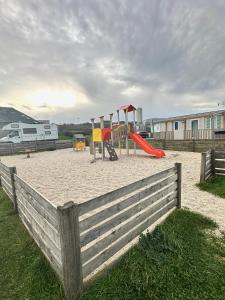 a playground with two swings and a slide at Blueportel Prestige in Le Portel