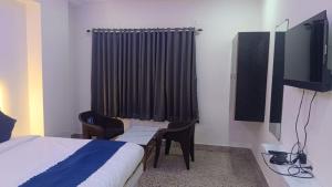 a hotel room with two beds and a tv at HoTEL JAGAPATHI INTERNATIONAL in Vijayawāda