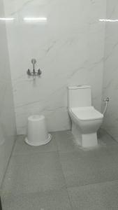 a white bathroom with a toilet and a sink at HoTEL JAGAPATHI INTERNATIONAL in Vijayawāda