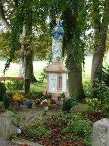 posąg kobiety na piedestale w ogrodzie w obiekcie Hotel Pfeffermühle w mieście Borchen