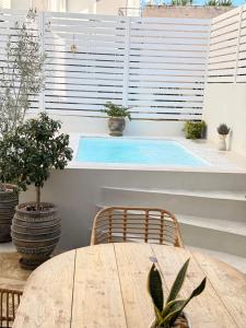 a patio with a table and a swimming pool at Myronos suite with jacuzzi in Piraeus