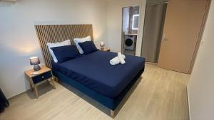 a bedroom with a blue bed with a teddy bear on it at L'Aparté des hibiscus in Les Trois-Îlets
