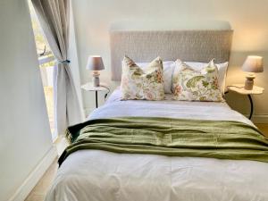 a bedroom with a bed with pillows and a window at Sea View Bliss in Ballito