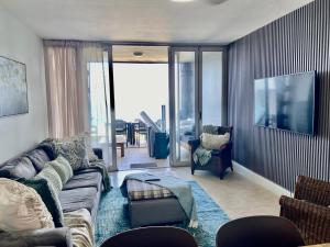 a living room with a couch and a tv at Sea View Bliss in Ballito