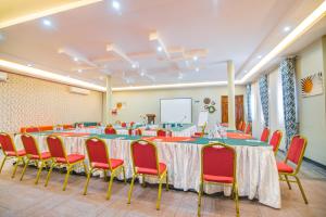 a conference room with a long table and red chairs at Hotel La vena in Kampala +147 photos