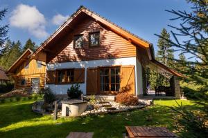 a small wooden house with a green yard at Chata Lienka in Lazisko