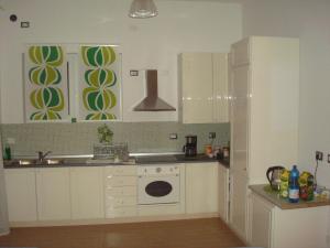 a kitchen with white cabinets and a sink and a dishwasher at Green Bed Bergamo Guest House & Residence in Bergamo +49 photos