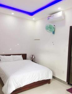 a bedroom with a white bed with a blue ceiling at Motel Thanh Long in Danang