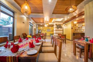 a restaurant with a long table with red napkins on it at Hotel La vena in Kampala