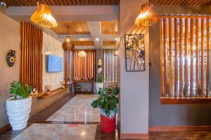 a lobby with two potted plants and two lights at Hotel La vena in Kampala