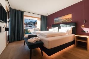 a bedroom with a large bed and a large window at Chalet Hohe Welt - luxury apartments in Lech am Arlberg +90 photos