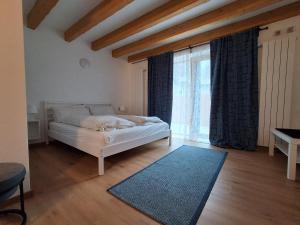 a bedroom with a bed and a large window at Chalet La coccola di Lulù in Molina di Ledro