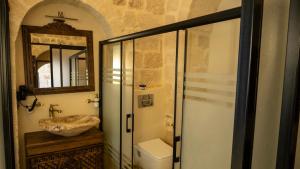 a bathroom with a sink and a toilet and a mirror at Vezir Konağı Hotel in Mardin