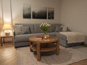 a living room with a couch and a table with flowers on it at Alte Remise Blankenburg in Blankenburg