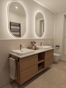 a bathroom with two sinks and two mirrors at Alte Remise Blankenburg in Blankenburg