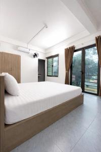 a bedroom with a large bed and windows at Đức Quỳnh Hotel in Ninh Binh